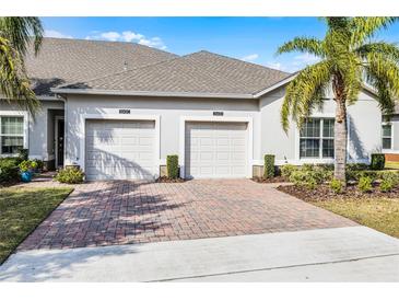 Two-car garage with brick paver driveway and manicured landscaping for a welcoming curb appeal at 3543 Fairwaters Ct # D, Clermont, FL 34711