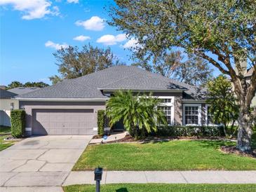 Charming single-story home with a well-maintained lawn, mature trees, and a two-car garage at 398 Lake Amberleigh Dr, Winter Garden, FL 34787