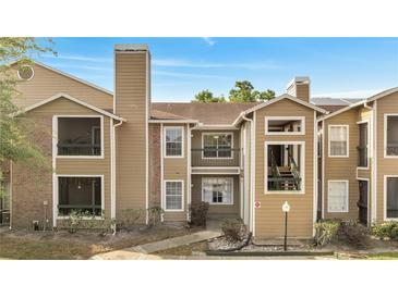 Charming condo with tan siding, brick accents, and cozy balconies under a bright blue sky at 4367 Thornbriar Ln # P204, Orlando, FL 32822