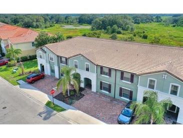 Charming townhome showcases a neatly bricked drive leading up to the attached two-car garage at 4607 Terrasonesta Dr, Davenport, FL 33837