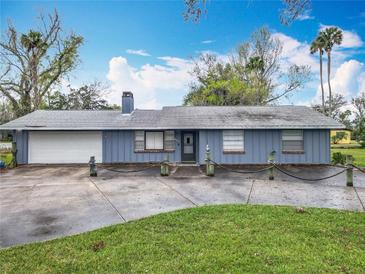 Charming single-story home featuring an attached garage, well-manicured lawn, and a unique nautical-themed front yard boundary at 607 Powers Ave, Port Orange, FL 32127