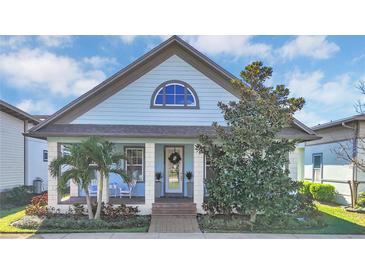 Charming single-story home featuring a cozy front porch, blue siding, manicured landscaping, and inviting curb appeal at 13333 Beebe Aly, Orlando, FL 32827