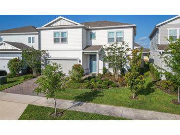 Charming two-story home showcasing a manicured lawn and lovely landscaping at 13348 Panama Beach Ct, Orlando, FL 32827
