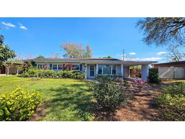 Single-story home with tidy landscaping, blue shutters, and an attached carport on a sunny day at 161 Randia Dr, Orlando, FL 32807