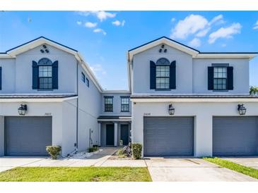 Charming townhomes with two stories, gray paint, black shutters, and attached garages at 20648 Maxim Pkwy Pkwy, Orlando, FL 32833