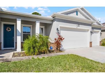 Inviting front entrance boasting a vibrant blue door, decorative wreath, and stone accents at 210 Cypress Trail Dr, Ormond Beach, FL 32174