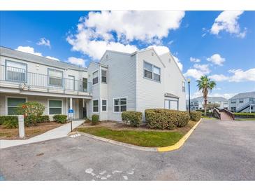 Exterior view of condo features manicured landscaping, accessible entrance, and assigned parking at 2540 Woodgate Blvd # 106, Orlando, FL 32822