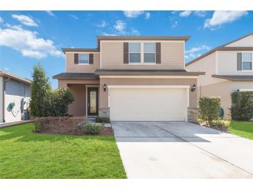 Charming two-story home featuring a manicured lawn, a two car garage, and craftsman style shutters at 3566 Southern Cross Loop, Kissimmee, FL 34744