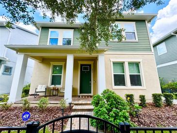 Charming two-story home with a cozy front porch, manicured landscaping, and a secure fenced yard at 453 Oviedo Blvd, Oviedo, FL 32765