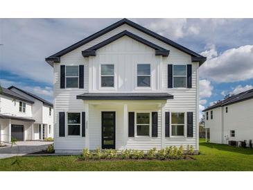 Charming two-story home with white siding, black shutters and a well-manicured front lawn at 1975 Peel Ave, Orlando, FL 32806