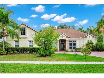 Elegant home featuring manicured landscaping, a beautiful lawn, and a welcoming brick entrance at 2932 Bayhead Run, Oviedo, FL 32765