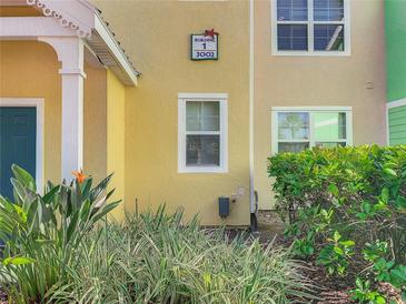 Building 1 facade shows bright yellow color, green bushes, and an exterior window at 3002 Bonfire Beach Dr # 202, Kissimmee, FL 34746