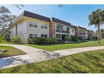 A welcoming condo complex with lush landscaping and well-maintained sidewalks on a bright, sunny day at 3800 Saxon Dr # 19B, New Smyrna Beach, FL 32169