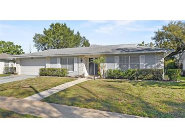 Well-maintained single-story home with stone accents, shutters, and a green lawn at 4913 E Wind St, Orlando, FL 32812