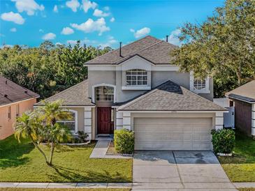 Charming two-story home with well-maintained lawn, mature trees, and attached two-car garage at 1096 Ballyshannon Pkwy, Orlando, FL 32828