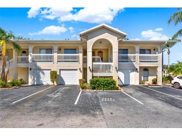 Two-story condo building with white balconies and garages under a blue sky at 3206 Sabal Palms Ct # A, Kissimmee, FL 34747