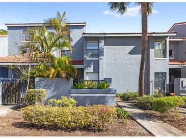 Charming townhome features lush landscaping, mature palm trees, and a walkway leading to the front entrance at 4713 Capri Pl # 190, Orlando, FL 32811