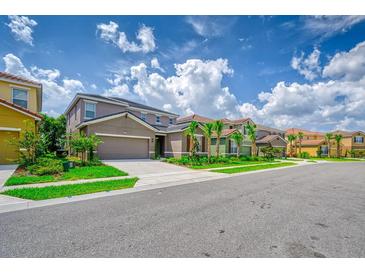 Beautiful two-story home with a well-manicured lawn, mature trees, and a two-car garage at 6090 Broad Oak Dr, Davenport, FL 33837