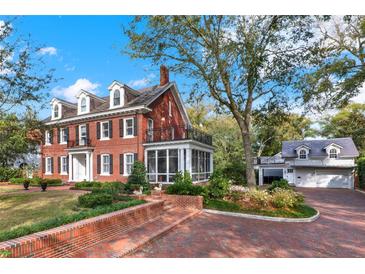 Stately red brick home with beautiful landscaping and a detached garage at 721 Delaney Ave, Orlando, FL 32801