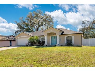 Charming single-story home featuring a well-manicured lawn and a welcoming blue front door at 970 Picasso Ave, Deltona, FL 32738