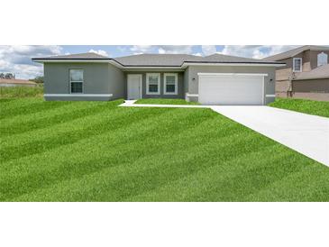 Inviting single-story home featuring a well-manicured lawn, attached garage, and a classic neutral exterior color at 13220 Sw 85Th Pl, Ocala, FL 34473