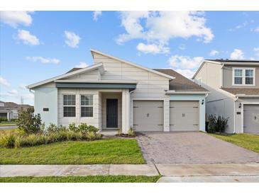 Charming single-Gathering home featuring a modern design, two-car garage, and well-manicured front lawn at 19307 Banfield Pl, Orlando, FL 32827