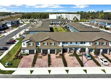 A high aerial view of a community showcasing townhomes with brick driveways and garages at 208 Cape Honeysuckle Pl, Sanford, FL 32771