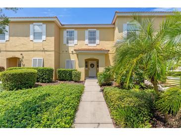 Charming townhouse with lush landscaping, pathway, and welcoming front entrance at 3133 Yellow Lantana Ln, Kissimmee, FL 34747