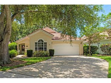 Charming single-story home with a well-manicured lawn, mature trees, and a two-car garage at 763 Via Milano, Apopka, FL 32712