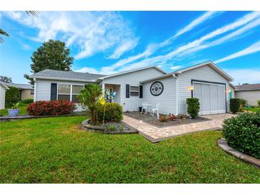 Charming single-story home with well-manicured lawn and vibrant landscaping on a sunny day at 7978 Se 174Th Belhaven Loop, The Villages, FL 32162