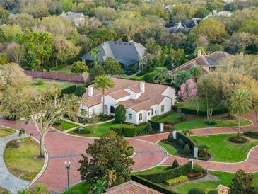 A beautiful aerial view of a property showcasing its lush landscaping and meticulously designed circular driveway at 9224 Bentley Park Cir, Orlando, FL 32819