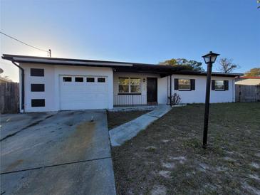 Charming single-story home featuring a well-maintained lawn, a covered porch, and an attached garage at 1616 Ferndell Rd, Orlando, FL 32808