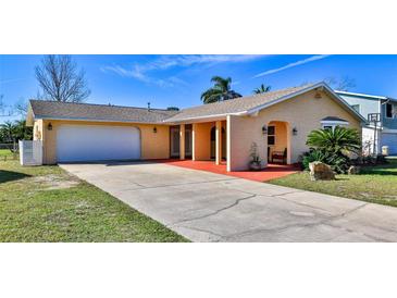 Charming single-story home featuring a two-car garage, stucco siding and a well-manicured lawn at 209 Georgetowne Blvd, Daytona Beach, FL 32119