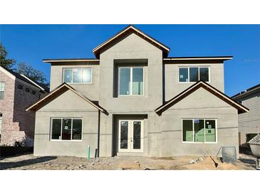 Two-story home featuring a modern design, gray stucco, and large windows that provide ample natural light at 3206 Harrison Ave, Orlando, FL 32804