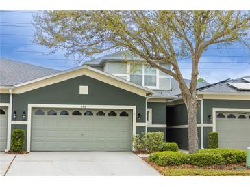 Inviting townhome featuring a gray exterior, a two-car garage, and manicured landscaping at 346 Canyon Stone Cir, Lake Mary, FL 32746