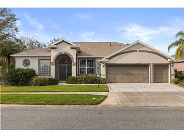Inviting single-story home with a well-manicured lawn, complemented by a 3 car garage and neutral color palette at 3603 Westover Cir, Leesburg, FL 34748