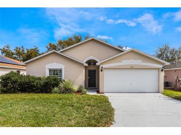 Charming single-story home with a well-maintained lawn and attached two car garage at 442 Jessamine Dr, Davenport, FL 33837