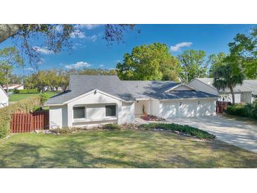 Charming single-story home featuring a well-manicured lawn, a three-car garage, and a cozy front entrance at 6735 Edgeworth Dr, Orlando, FL 32819