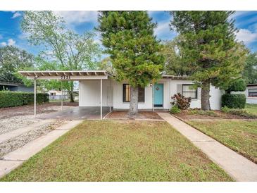 Charming single-story home featuring a covered carport, blue front door, and well-maintained front yard at 7121 Stockholm Way, Orlando, FL 32822