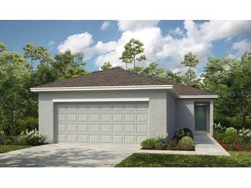 Charming one-story home featuring an attached two-car garage and a well-manicured lawn at 7359 Capstone Dr, Groveland, FL 34736