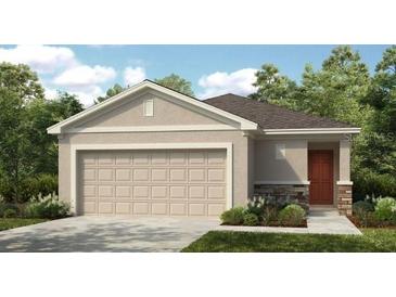 Charming single-story home with a two-car garage, neutral color palette, and manicured landscaping at 7363 Capstone Dr, Groveland, FL 34736