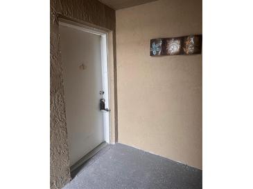 A secure entrance to a condo with gray floors and a neutral decor at 9916 Sweepstakes Ln # 1, Orlando, FL 32837