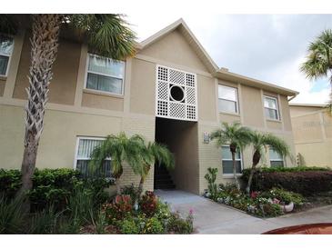 Inviting condo exterior with lush landscaping and tropical palm trees offering a serene and appealing entrance at 9916 Sweepstakes Ln # 1, Orlando, FL 32837