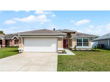Charming single-story home with a two-car garage, landscaped front yard, and red front door at 13254 Boulder Woods Cir, Orlando, FL 32824