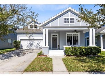 Charming two-story home featuring a covered front porch, well-maintained landscaping, and a two-car garage at 14225 Southern Red Maple Dr, Orlando, FL 32828