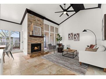 Bright living room with vaulted ceilings, stone fireplace, and lots of natural light at 178 W Sabal Palm Pl # 178, Longwood, FL 32779