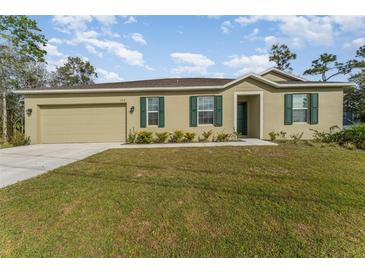 Charming single-story home with a well-manicured lawn, attached garage, and beautiful green shutters at 322 Dagama Ct, Kissimmee, FL 34758