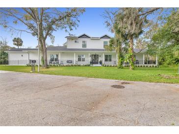 Charming two-story home features a welcoming porch, mature trees, and well-maintained landscaping at 599 Glendevon Dr, New Smyrna Beach, FL 32168