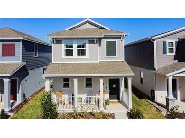 Charming two-story home features a welcoming front porch with a well-manicured lawn and beautiful landscaping at 6404 Pine Fork Aly, St Cloud, FL 34771