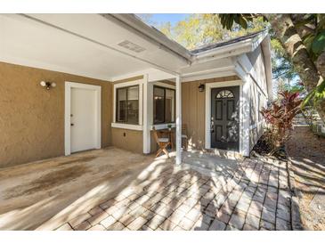 Charming front entrance with covered patio and brick pathway to a dark-colored front door at 703 Linden Dr, Winter Springs, FL 32708